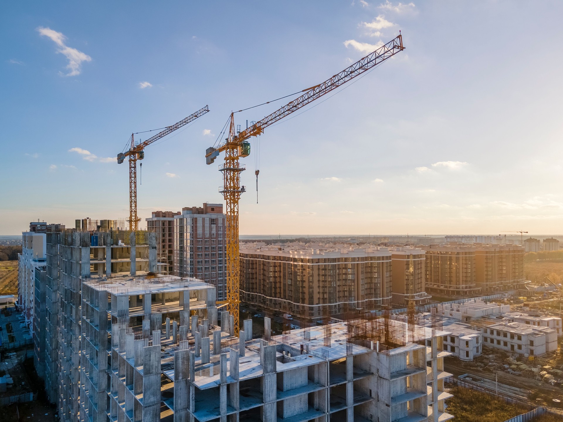 Cranes on the construction site surrounded by new real estates.
